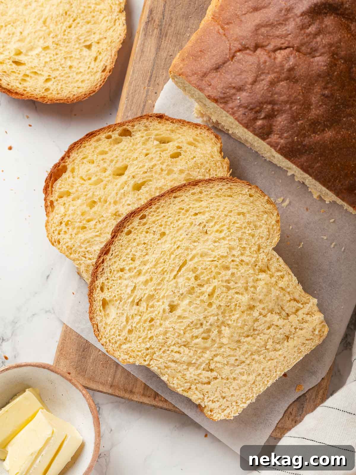 Tender Potato Loaf 23 A loaf of potato bread sliced on a wooden cutting board.
