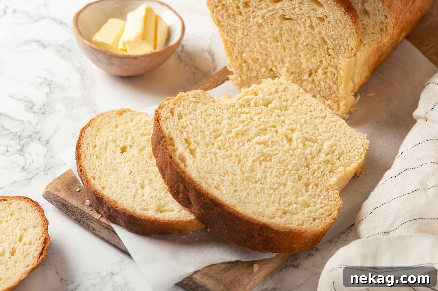 Tender Potato Loaf 5 Freshly baked bread with a butter dish beside it, perfect for serving.