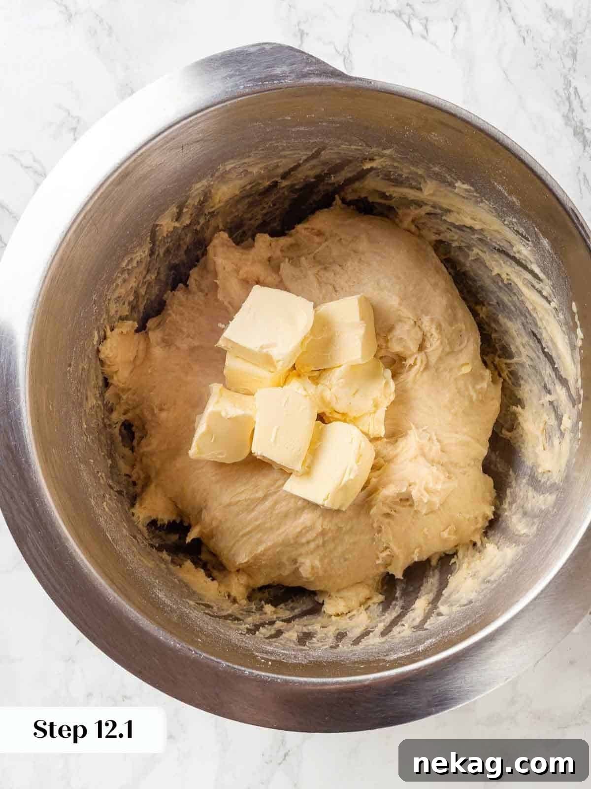 Tender Potato Loaf 10 Cubes of butter being added to the mixing bowl with dough in progress.