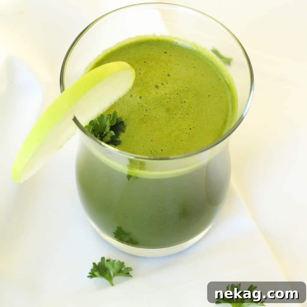 Close-up of various vibrant green vegetables and herbs, including different types of kale and parsley, for juicing
