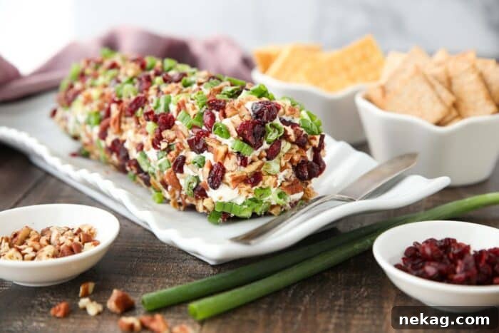 A festive Cranberry Pecan Cheese Log elegantly presented on a serving platter, ready to be enjoyed.