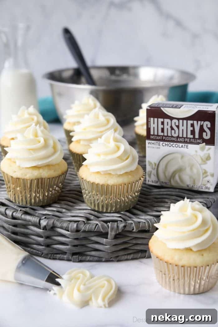 Delicious Pudding Buttercream Frosting Recipe 2 Cupcakes topped with white chocolate pudding buttercream frosting made with instant pudding mix.