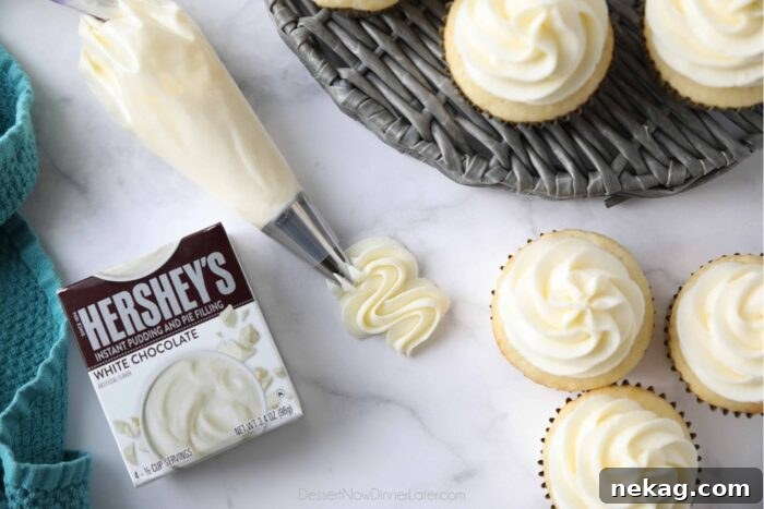 Delicious Pudding Buttercream Frosting Recipe 7 A box of Hershey's white chocolate instant pudding mix with frosting piped next to it and frosting piped on top of vanilla cupcakes.