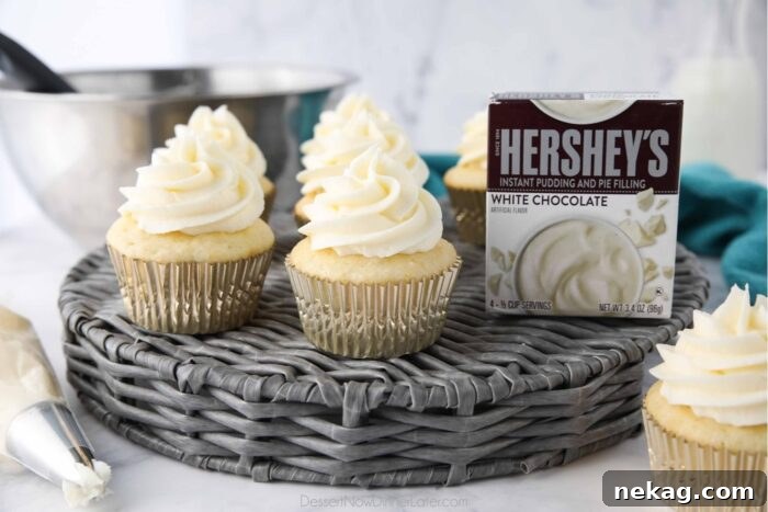 Delicious Pudding Buttercream Frosting Recipe 8 Front view of cupcakes topped with pudding buttercream frosting and a box of white chocolate pudding mix.