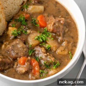 Delicious beef stew with carrots and parsley garnish.