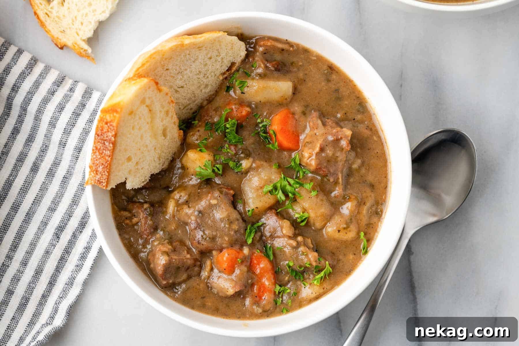 A bowl of beef stew with crusty bread, ready to be enjoyed.