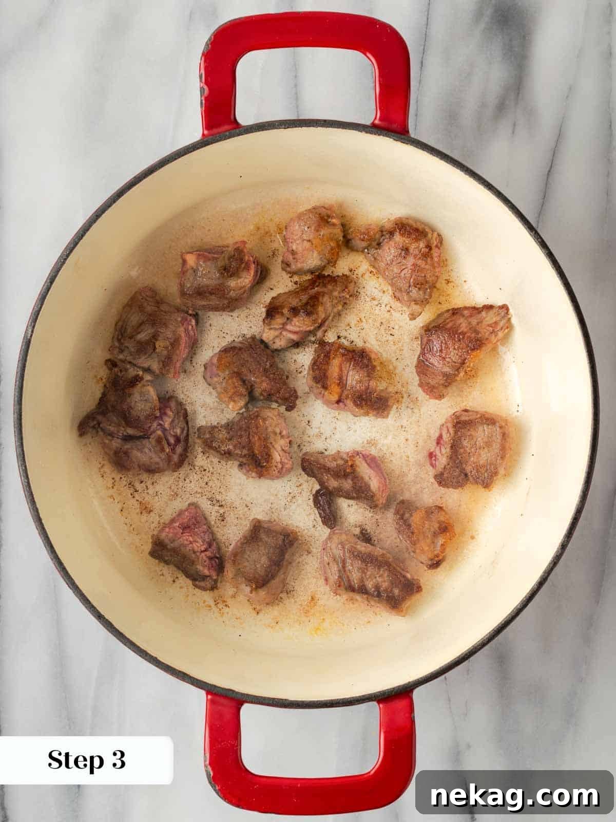 Searing flour-coated stew meat in a Dutch oven.