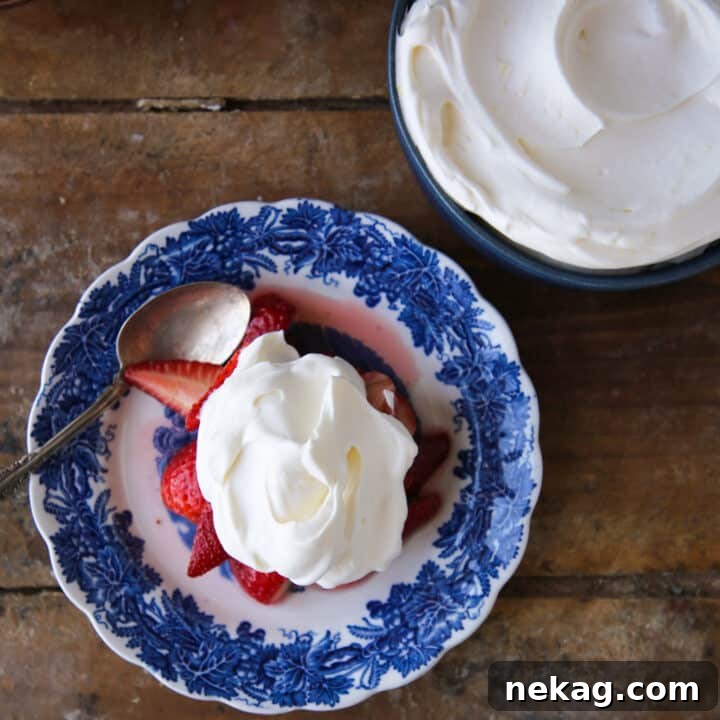 Whipped Citrus Bliss 3 Lemon Whipped Cream elegantly piped on a blue plate, garnished with fresh strawberries