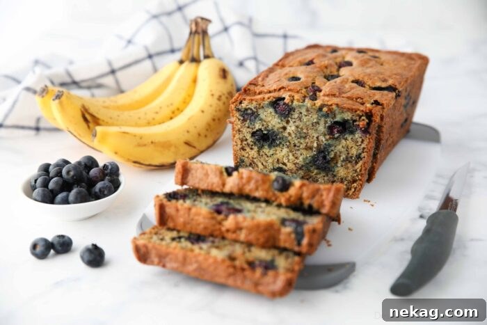 Berry-Kissed Banana Bread 8 A second view of a loaf of blueberry banana bread cut open to show its inviting, blueberry-studded interior.
