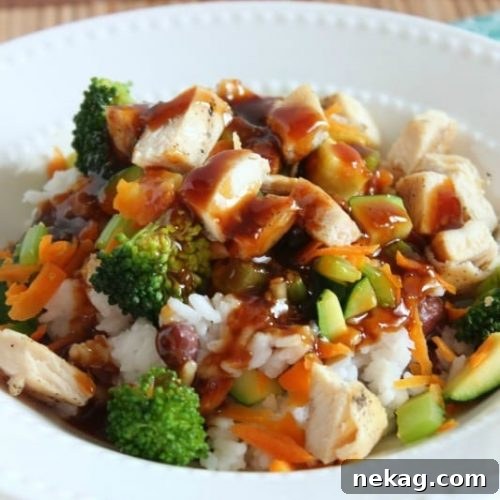 A beautifully plated Spicy Hawaiian Teriyaki Chicken Rice Bowl, showcasing all its components with the sauce drizzled over.