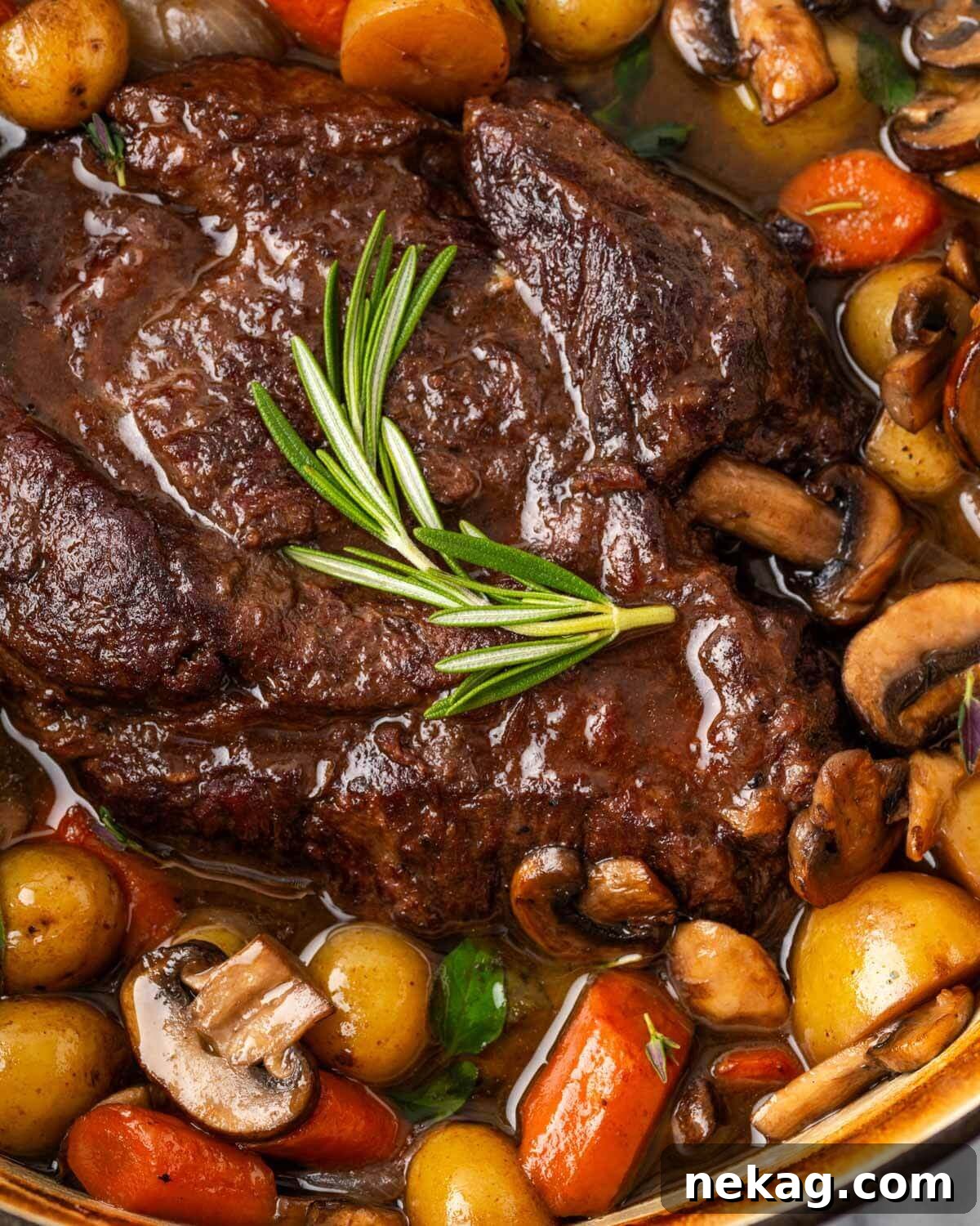 dutch oven cooked pot roast with carrots potatoes and mushrooms, beautifully plated.