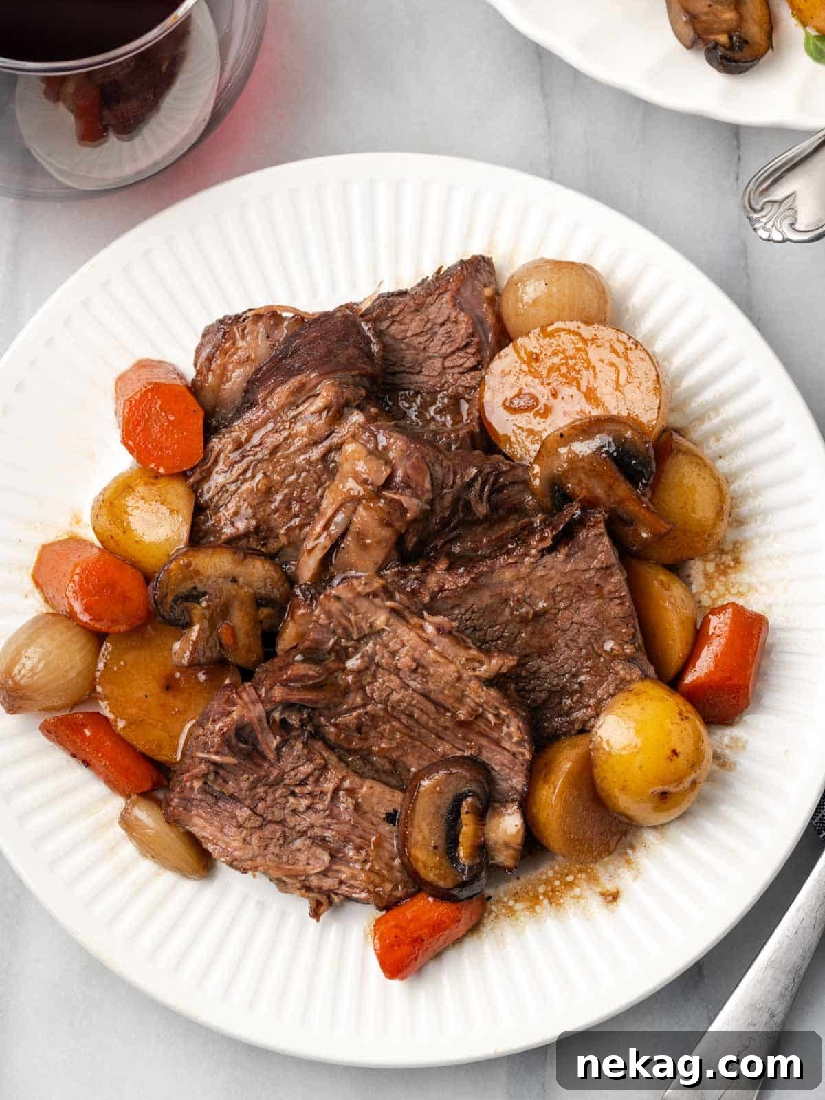close-up of perfectly sliced pot roast with tender vegetables and rich gravy.