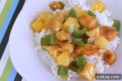 A close-up of Sweet and Sour Chicken, showcasing the crispy chicken pieces and vibrant sauce.