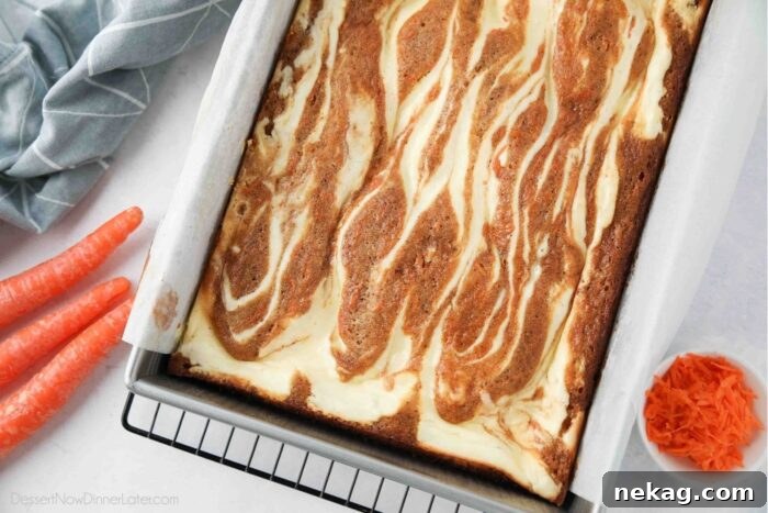 Decadent Carrot Cake Cheesecake Bars 11 A pan of Carrot Cake Blondies swirled with cream cheese, freshly baked.