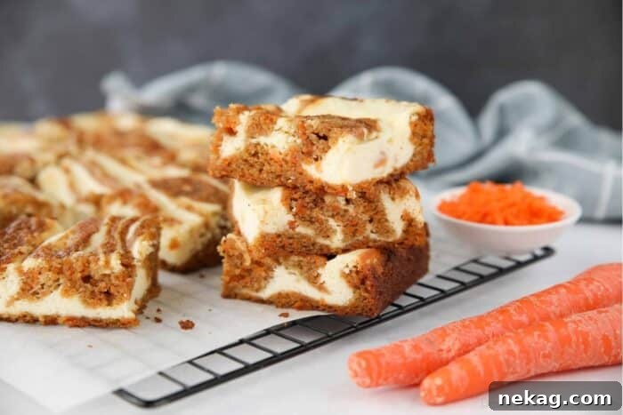 Decadent Carrot Cake Cheesecake Bars 12 Three Carrot Cake Cream Cheese Bars stacked on top of each other, ready to be served.