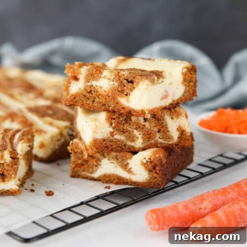 Three Carrot Cake Cream Cheese Bars stacked on top of each other.