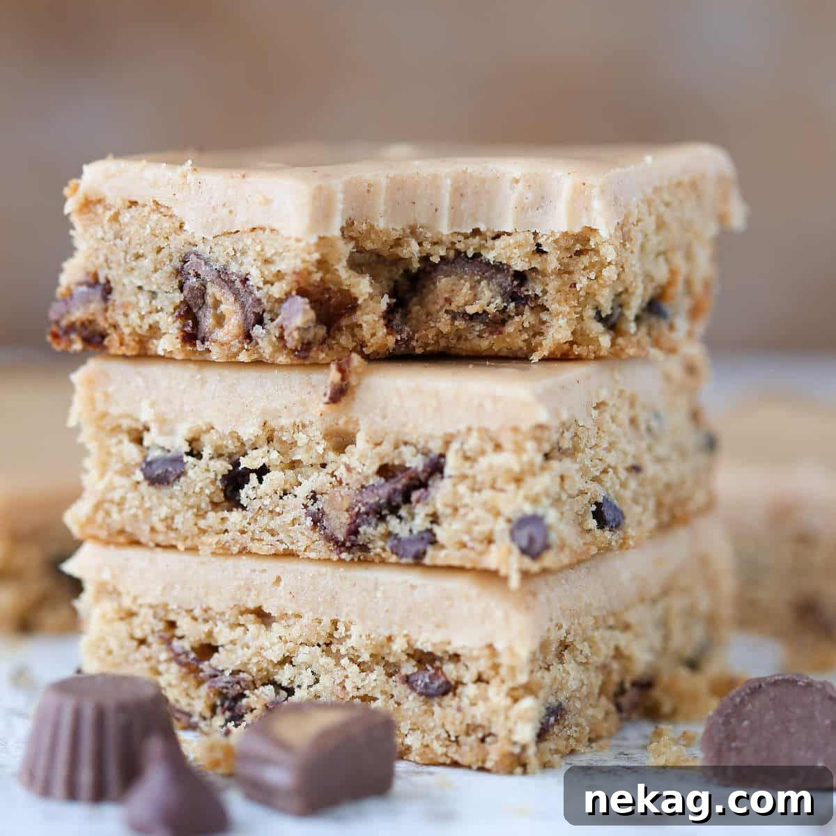 Ultimate Reeses Peanut Butter Blondies 2 A perfectly baked Reese's Peanut Butter Blondie with a bite taken out, revealing the chewy interior and abundant Reese's and chocolate chips.