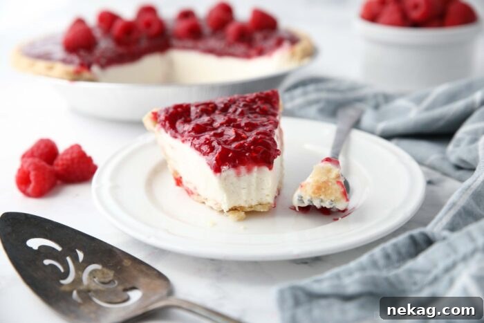 Slice of Raspberry Cream Pie on a plate with a forkful taken out.