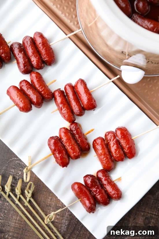 A bowl of cooked Crockpot Little Smokies with toothpicks, showing their plump, glazed appearance.
