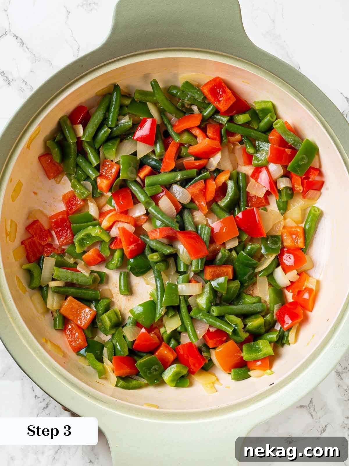 A visual step demonstrating the sautéing of colorful vegetables for the shrimp curry base.