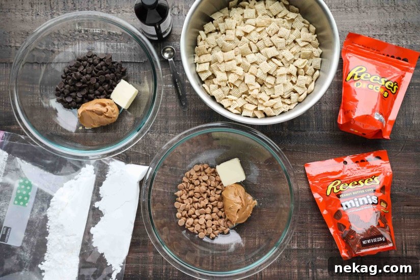 Ingredients laid out for making Reese's Muddy Buddies, including cereal, chocolate chips, peanut butter, butter, vanilla, powdered sugar, Reese's Pieces, and Reese's Minis.