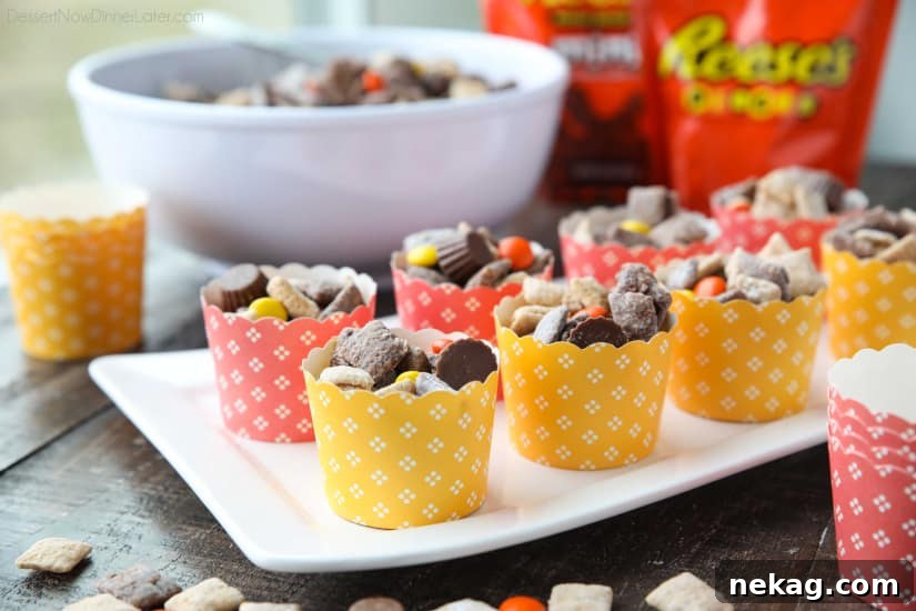 Individual decorative cups filled with Reese's Muddy Buddies, ready for serving at a party or game day.