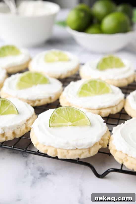 Coconut Lime Sugar Cookies - an easy sugar cookie recipe with a tropical fruit twist. You'll love these moist sugar cookies with a hint of lime, creamy coconut frosting, and a fresh lime wedge to squeeze on top. A Twisted Sugar copycat recipe.