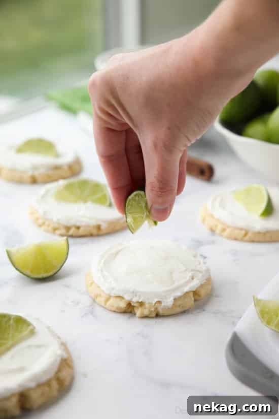 Coconut Lime Sugar Cookies - an easy sugar cookie recipe with a tropical fruit twist. You'll love these moist sugar cookies with a hint of lime, creamy coconut frosting, and a fresh lime wedge to squeeze on top. A Twisted Sugar copycat recipe.
