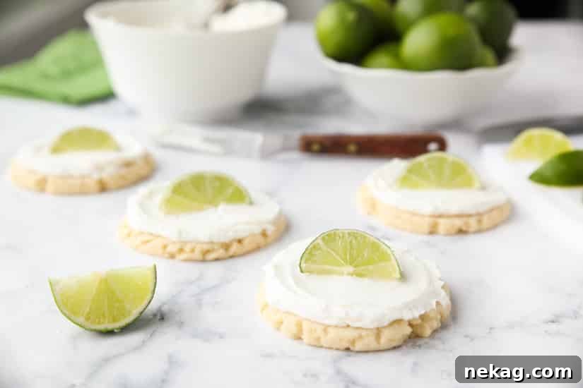 Coconut Lime Sugar Cookies - an easy sugar cookie recipe with a tropical fruit twist. You'll love these moist sugar cookies with a hint of lime, creamy coconut frosting, and a fresh lime wedge to squeeze on top. A Twisted Sugar copycat recipe.