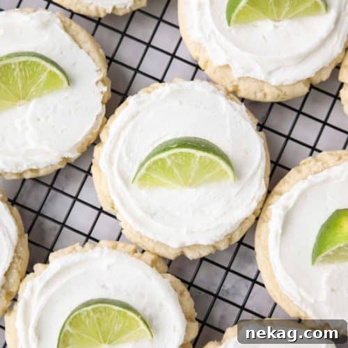 Coconut Lime Sugar Cookies - an easy sugar cookie recipe with a tropical fruit twist. You'll love these moist sugar cookies with a hint of lime, creamy coconut frosting, and a fresh lime wedge to squeeze on top. A Twisted Sugar copycat recipe.