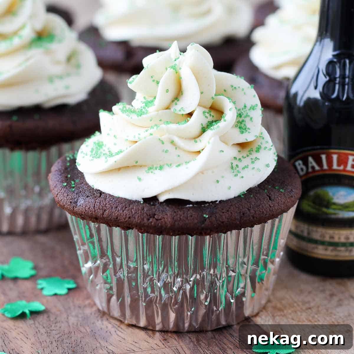 Cupcakes in front of a Baileys Irish Cream bottle.