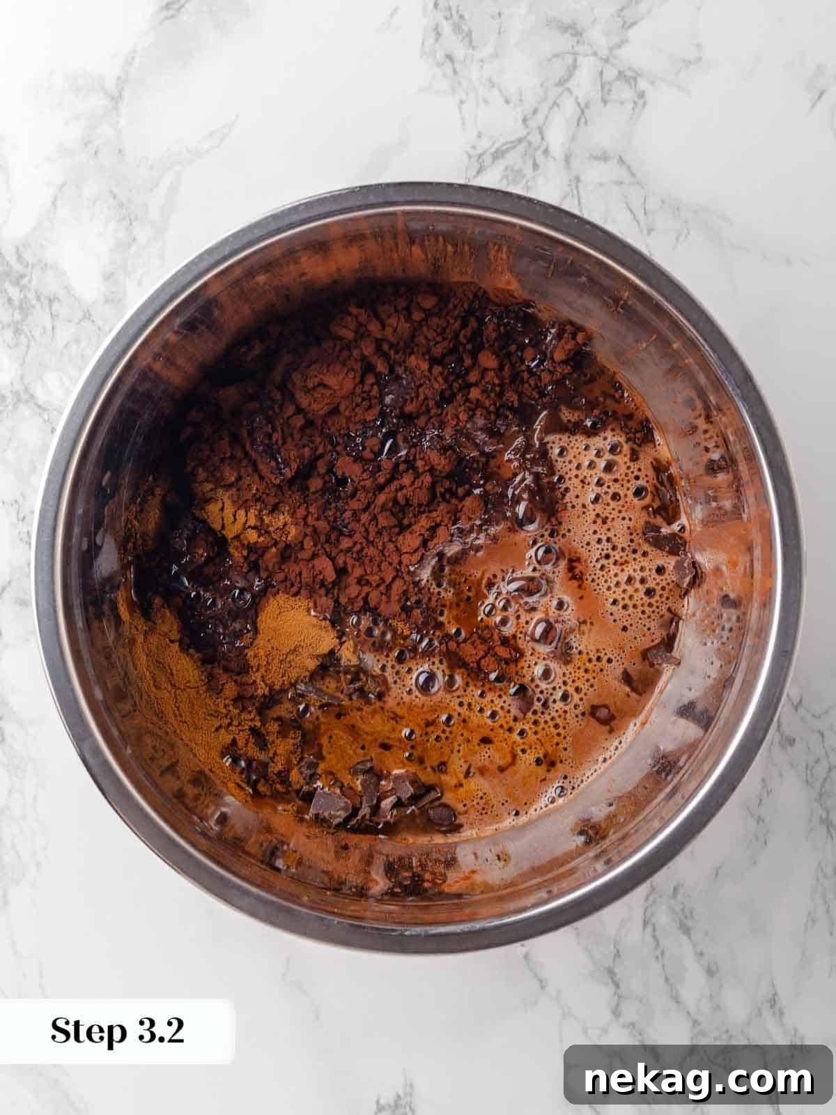 Warm stout being poured over a mixture of cocoa powder, chopped chocolate, and espresso powder, beginning the melting process.