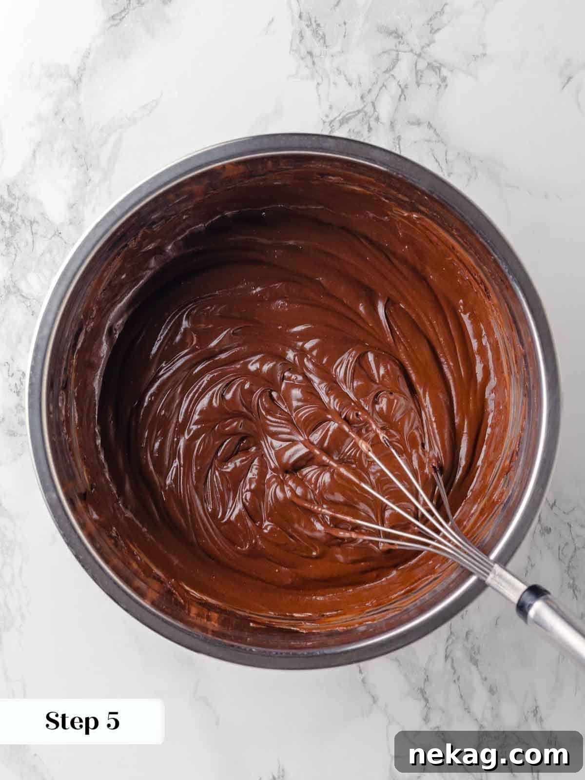 Sour cream whisked into the cooled chocolate-Guinness mixture until it's smooth and creamy, forming the base of the wet ingredients.