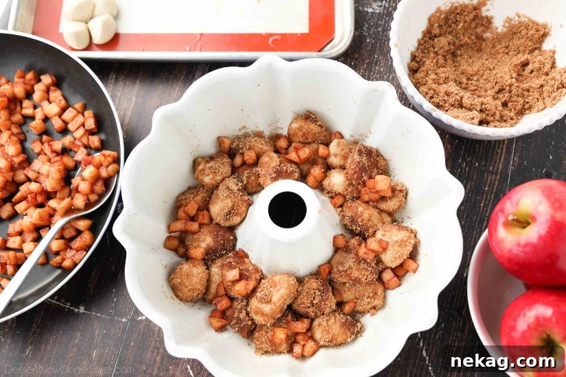 Apple Fritter Monkey Bread - Layering apples with cinnamon-sugar coated bread pieces.