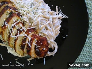 Close-up of raw chicken breasts generously coated with a dark, savory blackened seasoning blend, ready for searing.