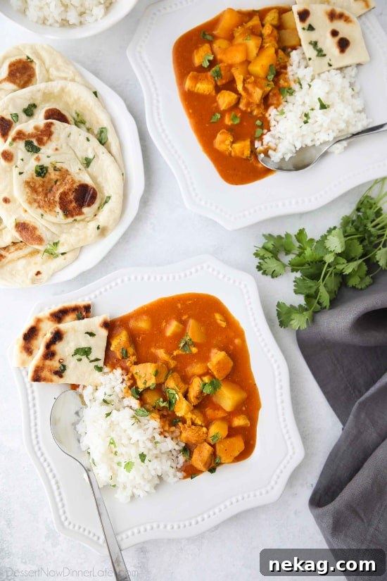 One-Pot Indian Butter Chicken with Potatoes 5 A serving of Instant Pot Indian Butter Chicken in a white bowl, showing the generous portions of chicken and potatoes coated in the thick, orange sauce.