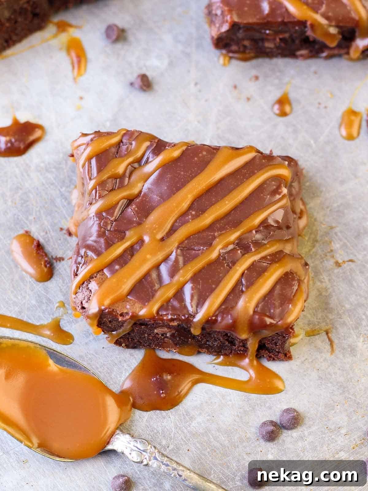 Decadent Caramel Brownies 5 A freshly cut caramel brownie showing its rich, fudgy interior, caramel swirls, and thick ganache topping.