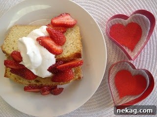 Hand serving pound cake with strawberries and whipped cream