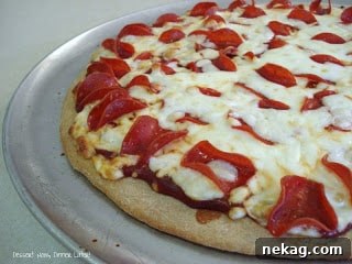 Homemade pizza with pepperoni and cheese, ready for baking