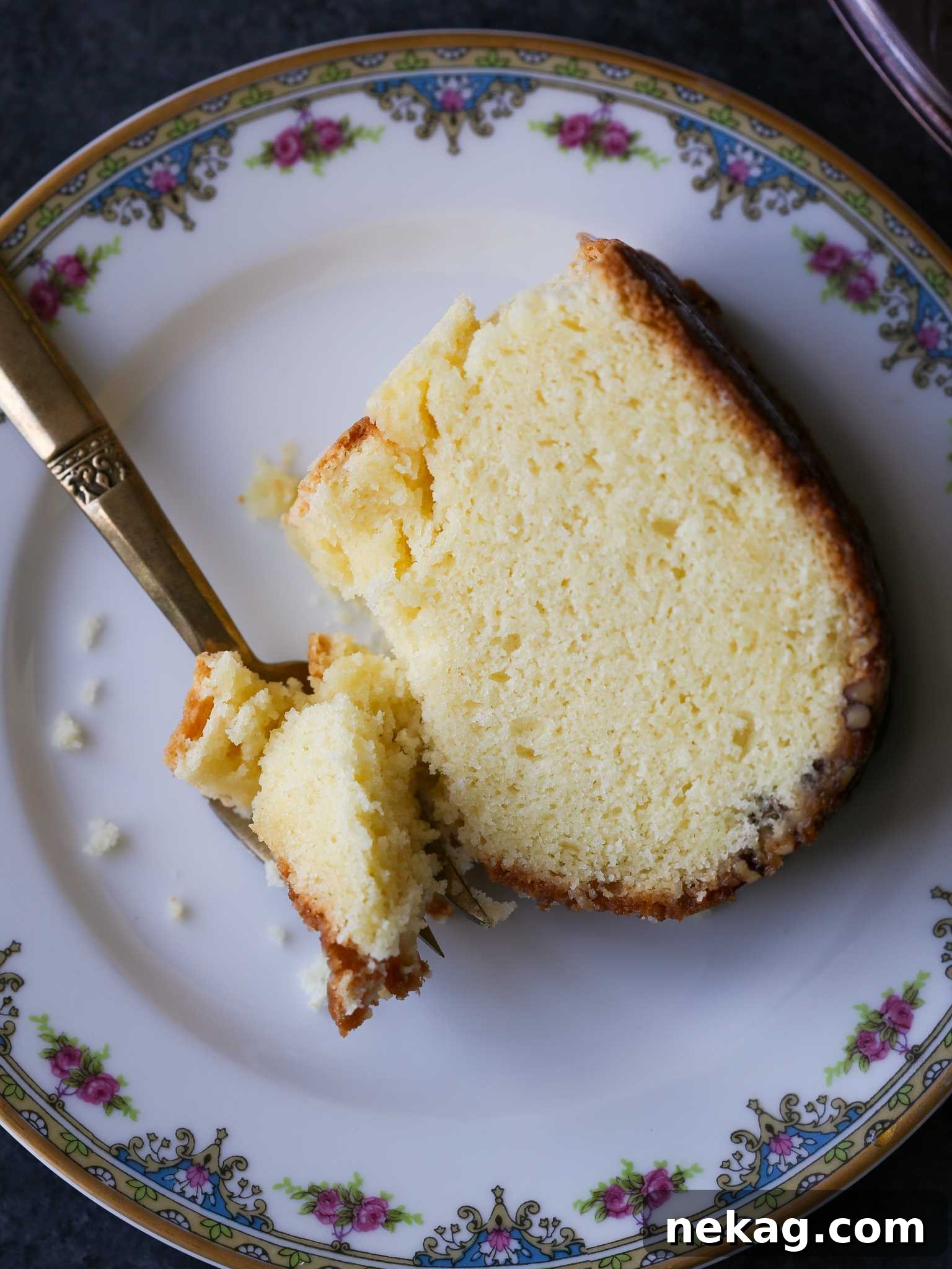 Spirited Bacardi Delight 8 A perfectly sliced piece of Bacardi Rum Cake on a vintage plate with a gold fork, ready to be enjoyed.