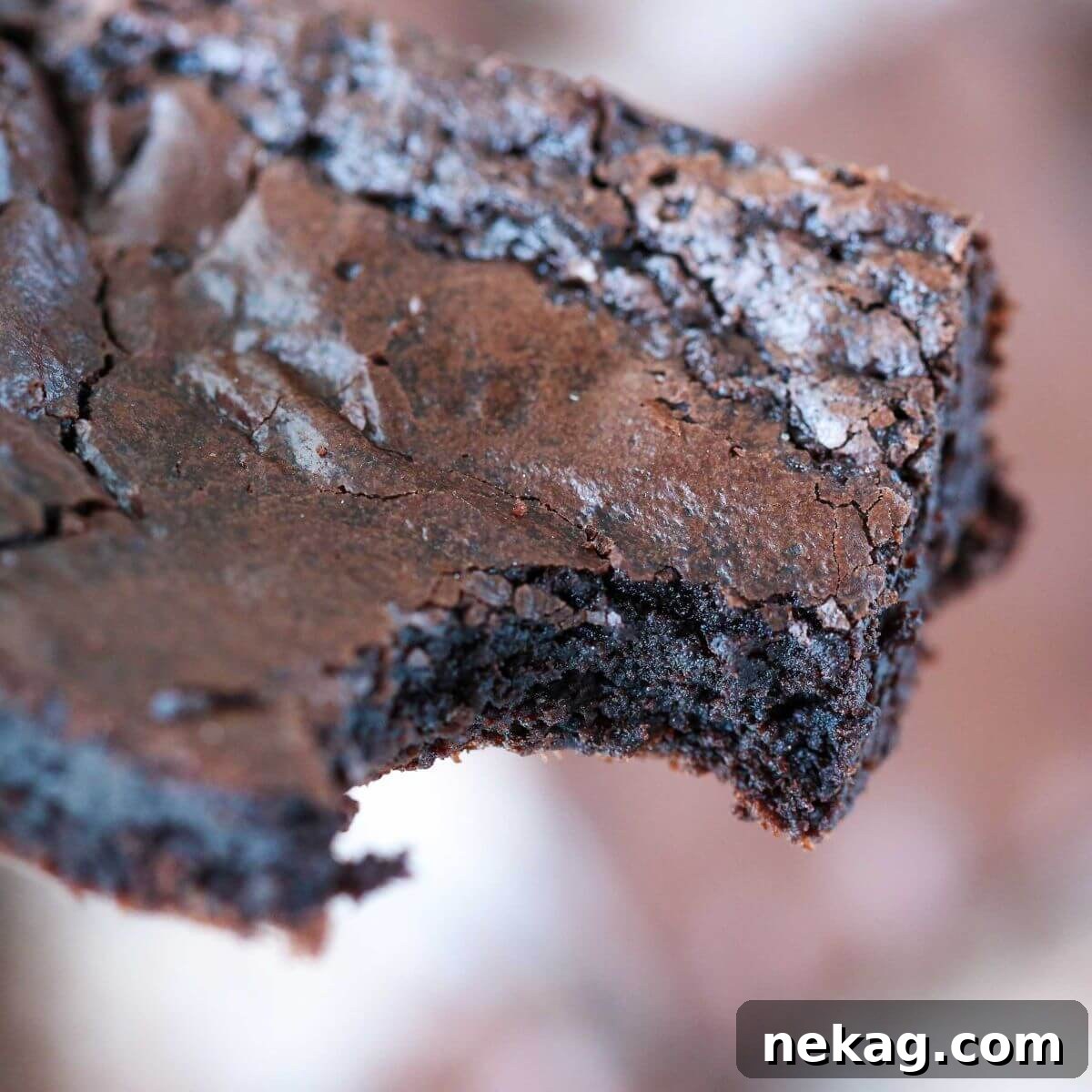 Lazy Day Brownies 4 A close-up of a bitten one-bowl brownie square, showing its rich, fudgy interior and flaky top.