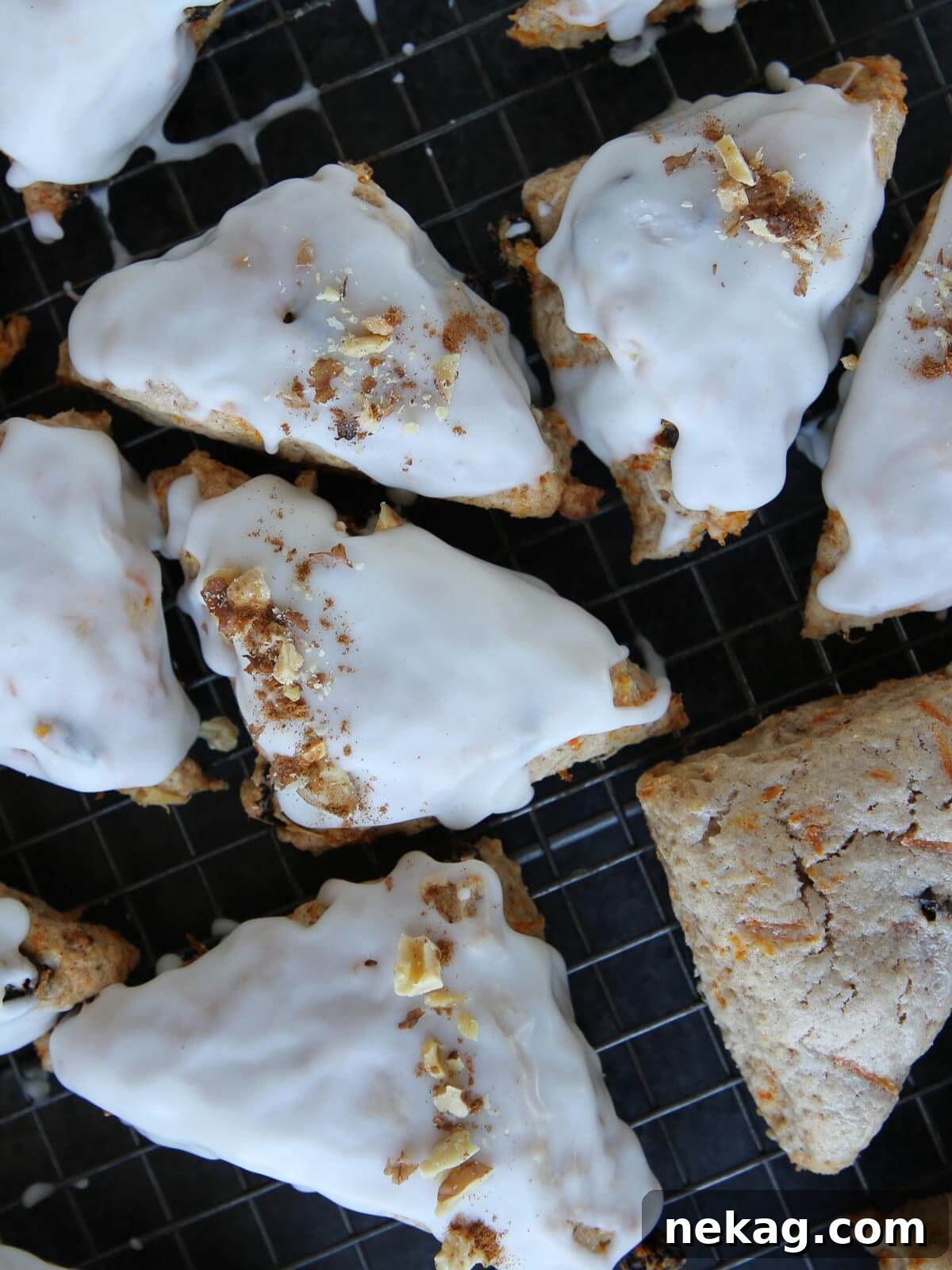 Spiced Carrot Cake Scones 4 Freshly baked carrot scones cooling on a wire rack, with the cream cheese glaze beginning to harden.