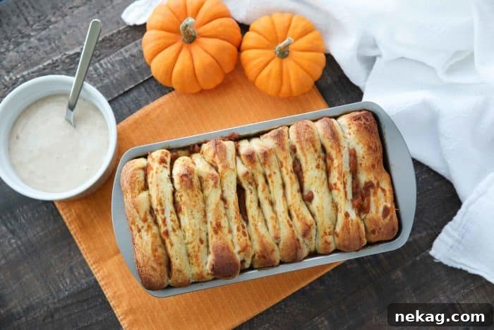 A glorious shot of Pumpkin Pull Apart Bread baking in a loaf pan, showcasing its rising dough and beginning to develop a beautiful golden-brown crust.
