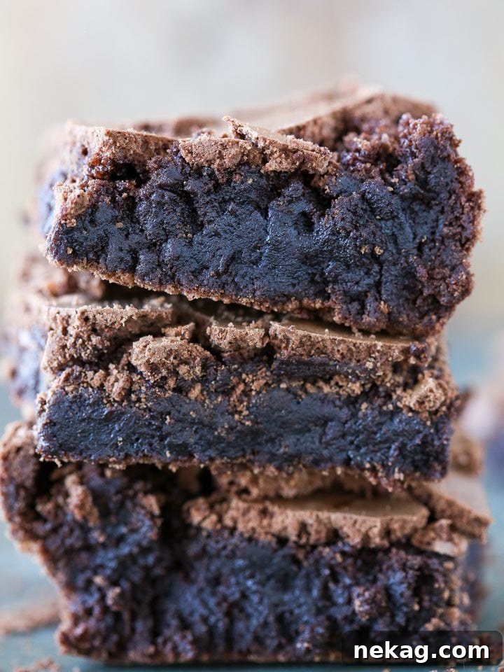 Nutty Brown Butter Brownies 2 A stack of three rich, fudgy brown butter brownies, showcasing their appealing chewy texture and crinkly tops.
