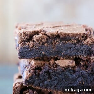 Detailed close-up of a single brown butter brownie, highlighting its crackly top and moist, dense texture.