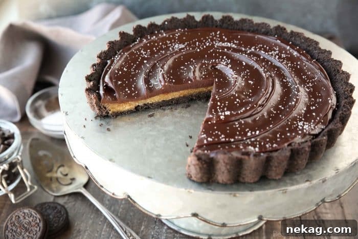 Easy Chocolate Caramel Tart with Oreo crust, soft caramel, and creamy chocolate ganache topped with flaky salt, a rich and satisfying dessert.
