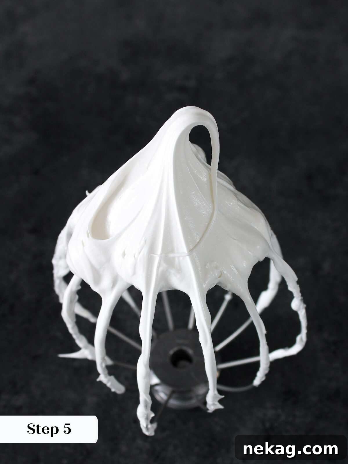Finished marshmallow fluff on a whisk, showcasing its perfect texture.