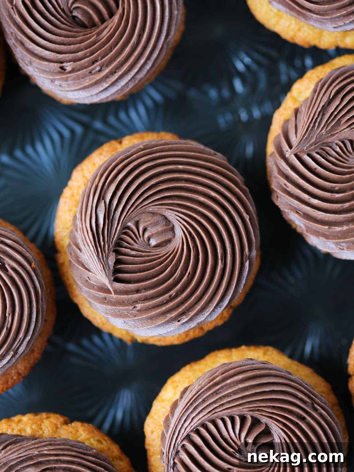 Velvet Chocolate Caramel Wonders 2 swirls of chocolate butter cream on cupcakes black background.