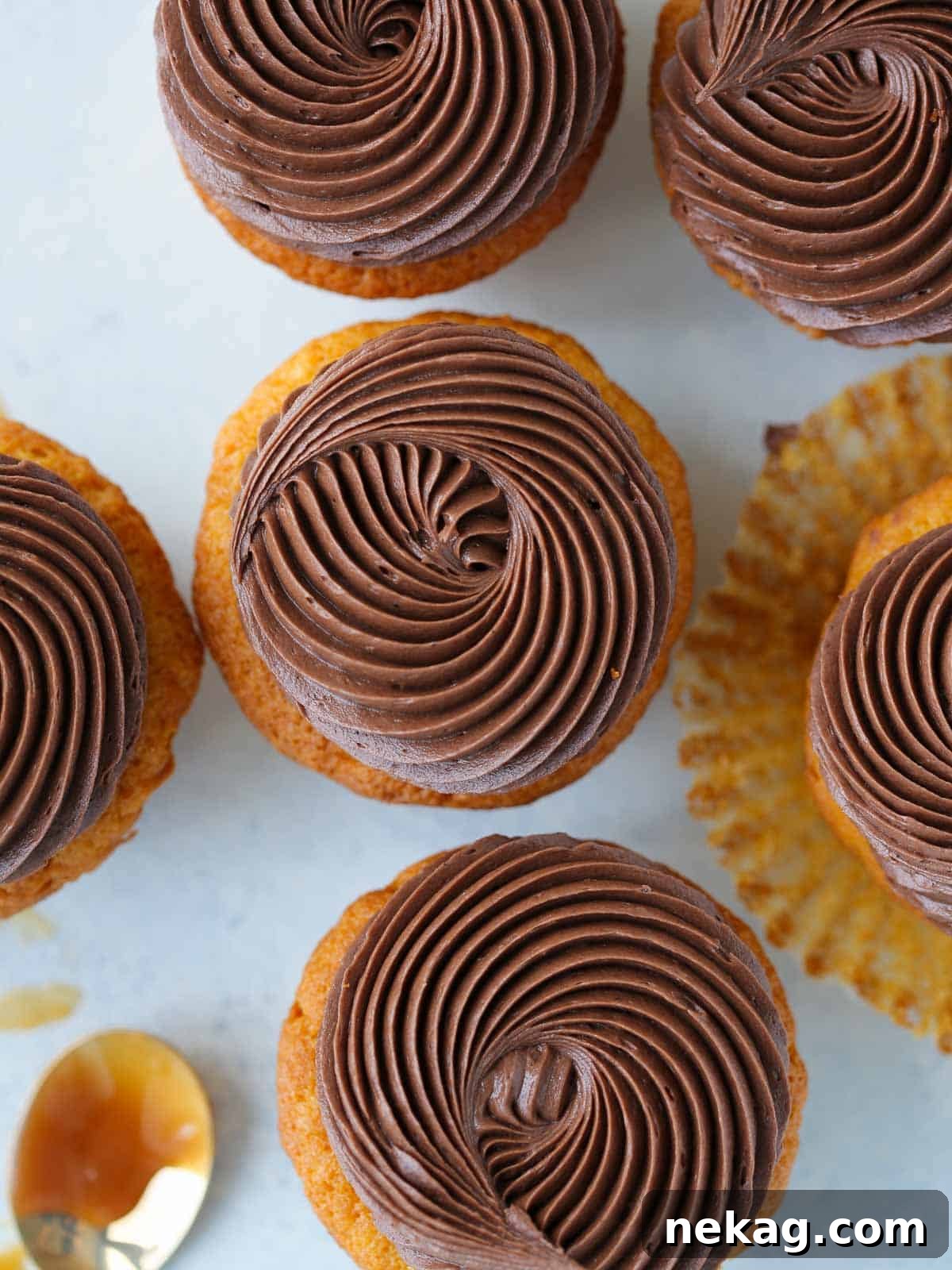 Velvet Chocolate Caramel Wonders 4 swirls of chocolate butter cream on cupcakes blue background.