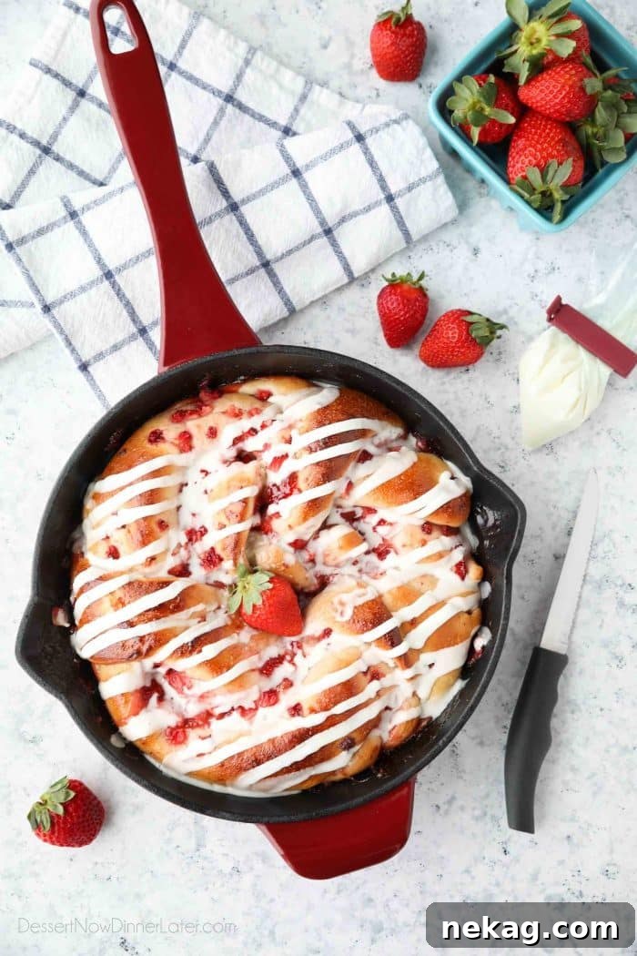 Strawberry Swirl Bread is a twist on classic sweet rolls. Sweet strawberry preserves and chunks of fresh strawberries are twisted inside of soft yeast bread, then baked until golden. Top it with a creamy icing and this easy sweet bread is perfect for breakfast or dessert.